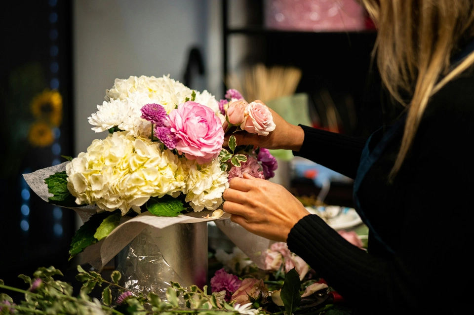 a florists building a colourful bouquet of flowers